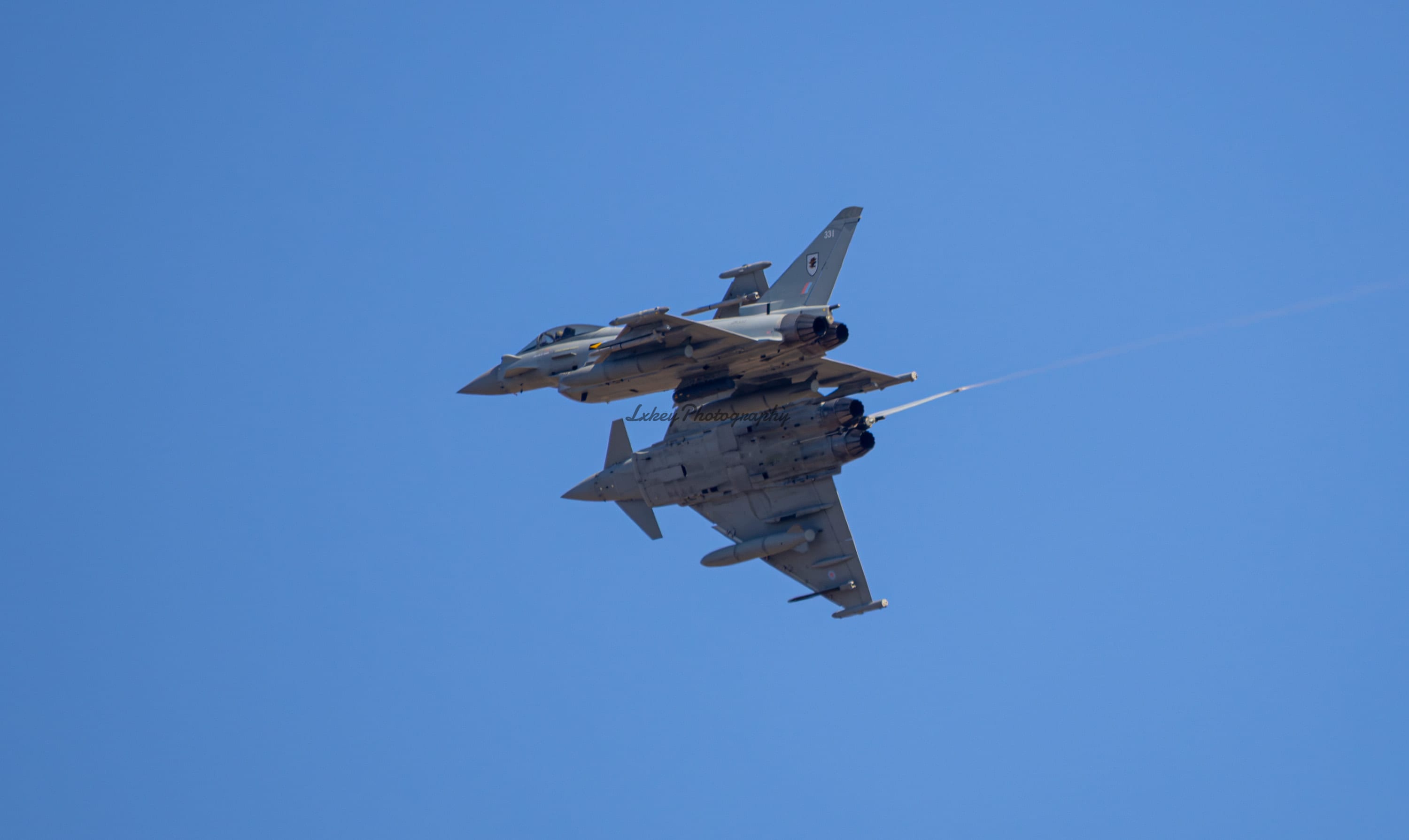 Pair of RAF Eurofighter Typhoons banking away from formation