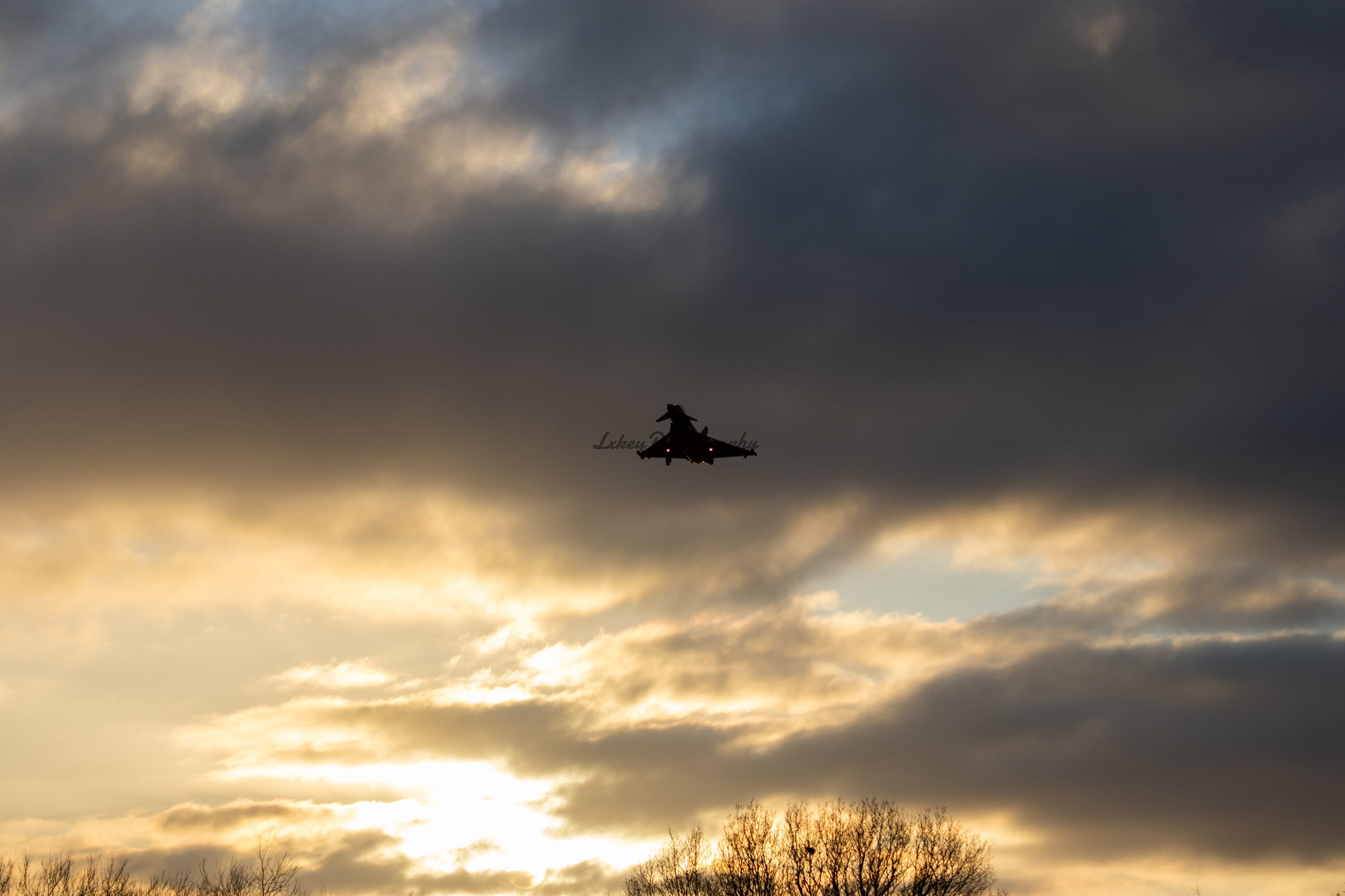 Typhoon silhouette recovering through a gap in heavy dusk cloud
