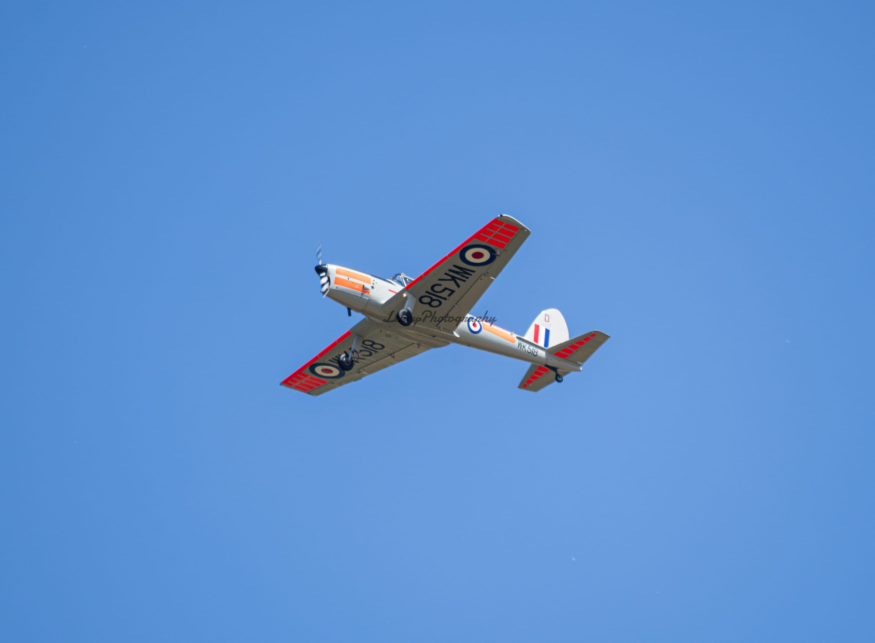 Historic military trainer rolling into a wing over