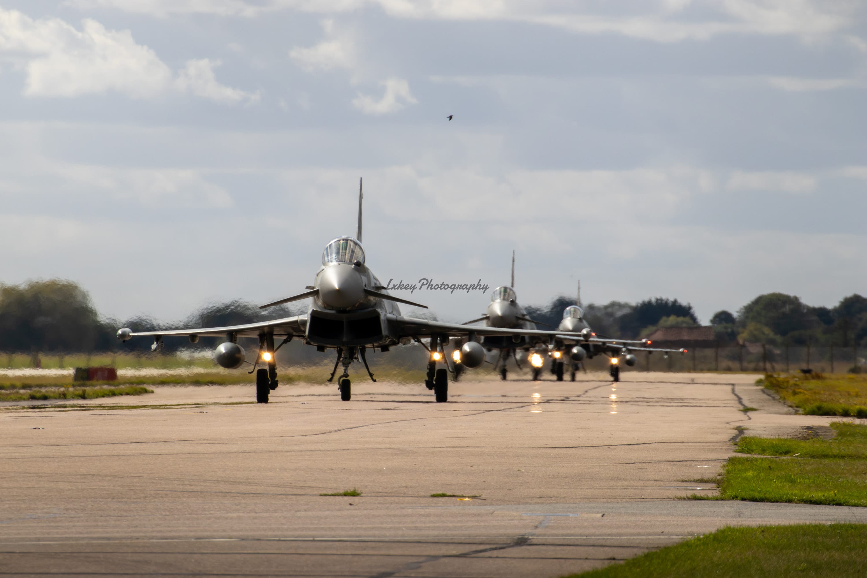 Four Royal Air Force Eurofighter Typhoons taxiing in sequence towards the runway at RAF Coningsby
